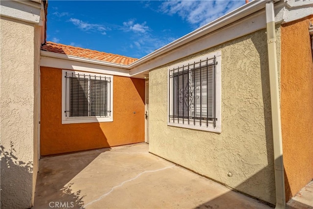 3738 Harrison St Unit 31, Riverside, CA 92503 - view of side of home featuring a patio area, a tiled roof, and stucco siding