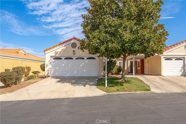 3738 Harrison St Unit 31, Riverside, CA 92503 - view of front facade with a garage, stucco siding, a tiled roof, and concrete driveway
