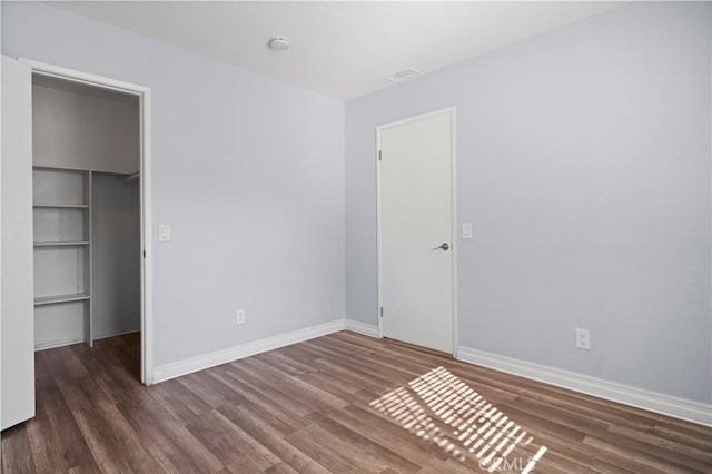 3738 Harrison St Unit 31, Riverside, CA 92503 - unfurnished bedroom featuring baseboards, wood finished floors, a closet, and a walk in closet