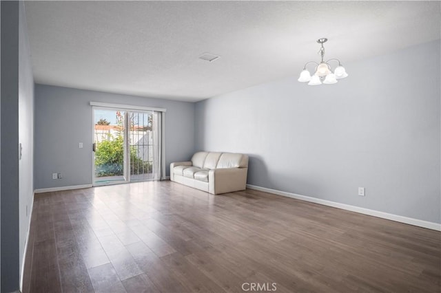 3738 Harrison St Unit 31, Riverside, CA 92503 - spare room featuring baseboards, dark wood-style floors, and an inviting chandelier