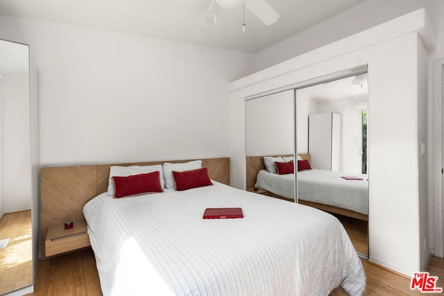 bedroom featuring hardwood / wood-style floors, ceiling fan, and a closet