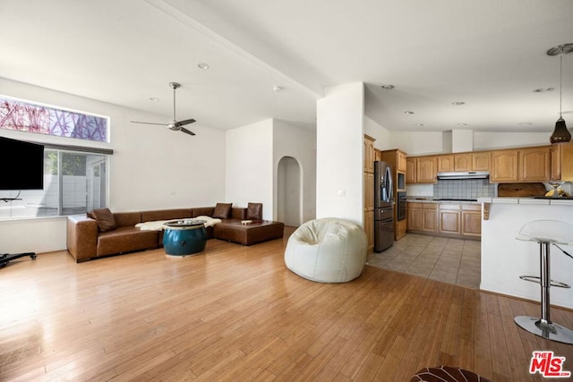 living room with ceiling fan, lofted ceiling, and light hardwood / wood-style flooring