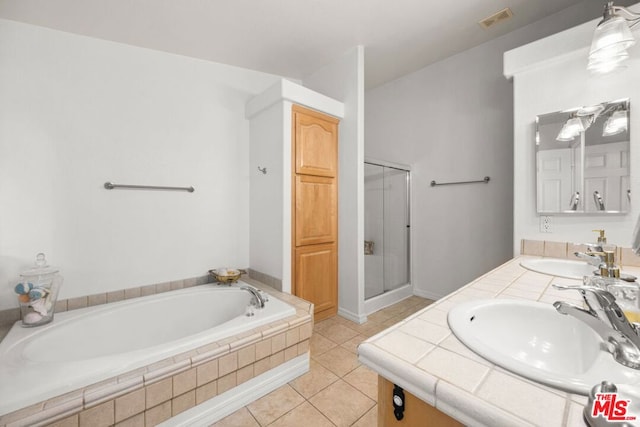 bathroom with tile patterned flooring, vanity, and separate shower and tub