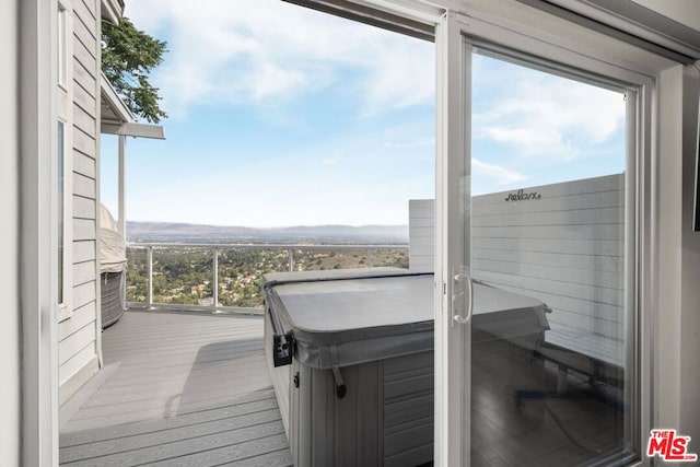 wooden deck featuring a hot tub and a mountain view