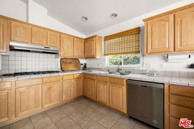 kitchen featuring dishwasher, lofted ceiling, sink, tile counters, and gas stovetop