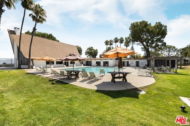 view of swimming pool featuring a yard and a patio area