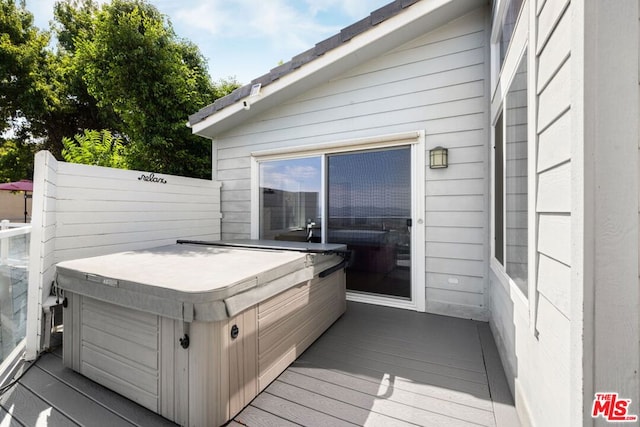 wooden deck featuring a hot tub