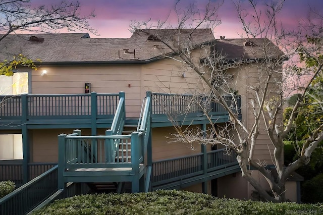 back house at dusk featuring a balcony