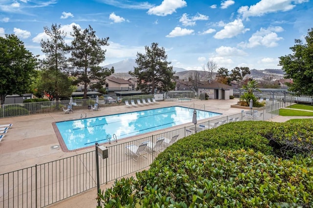 view of swimming pool featuring a patio and a mountain view