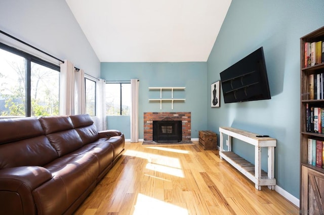 living room featuring a fireplace, plenty of natural light, and light hardwood / wood-style floors