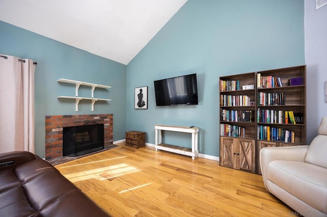 living room featuring light hardwood / wood-style flooring, a fireplace, and lofted ceiling