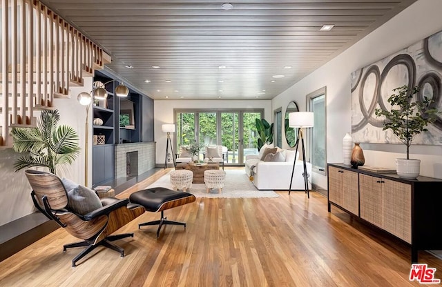 living room featuring wood ceiling, hardwood / wood-style flooring, and a fireplace