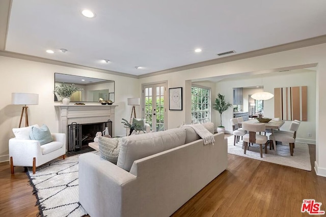 living room featuring hardwood / wood-style floors, ornamental molding, and french doors