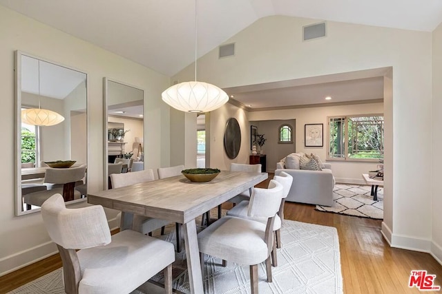 dining space featuring light hardwood / wood-style flooring and vaulted ceiling