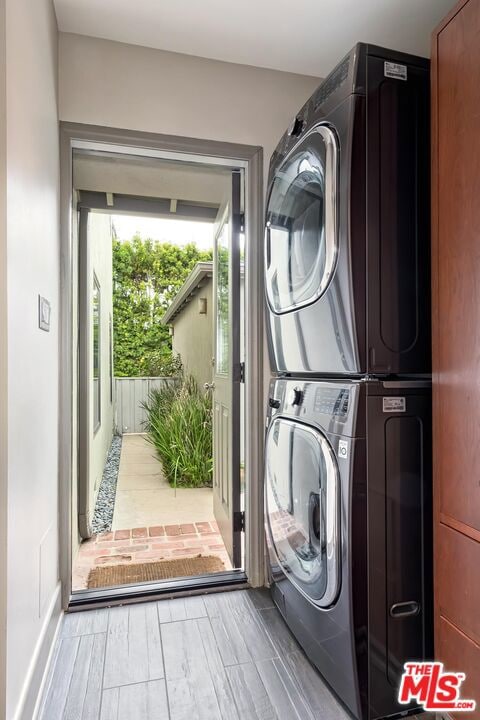 washroom with stacked washing maching and dryer