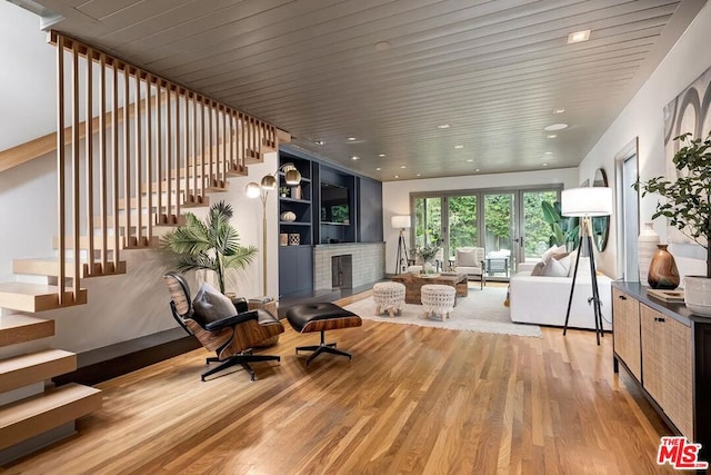 living room with wood ceiling, a fireplace, and light hardwood / wood-style flooring