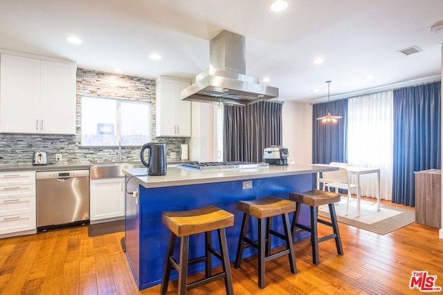 kitchen with stainless steel appliances, island exhaust hood, a center island, and white cabinets