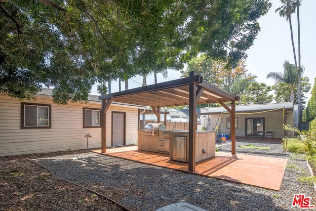 view of patio with an outdoor kitchen and a grill