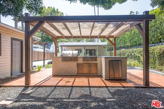 view of patio / terrace featuring a pergola, grilling area, and an outdoor kitchen