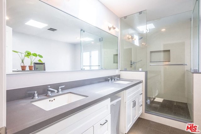 bathroom featuring tile patterned floors, vanity, and a shower with door