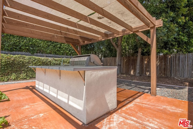 view of patio featuring an outdoor kitchen, grilling area, and a pergola