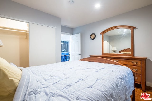 bedroom with wood-type flooring and a closet