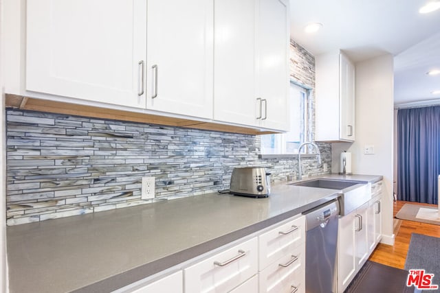 kitchen featuring sink, stainless steel dishwasher, and white cabinets