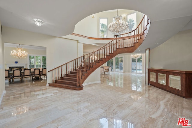 staircase with a towering ceiling and a chandelier