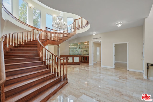 stairway featuring a notable chandelier and a high ceiling