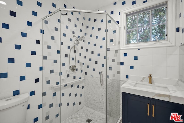 bathroom with tile walls, an enclosed shower, vanity, decorative backsplash, and toilet