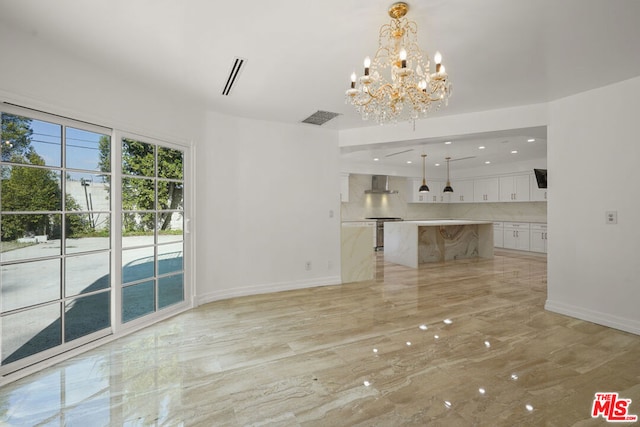 unfurnished living room featuring a chandelier