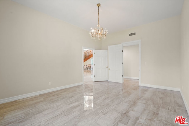 spare room with a chandelier