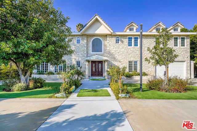 view of front of home with a garage and a front yard