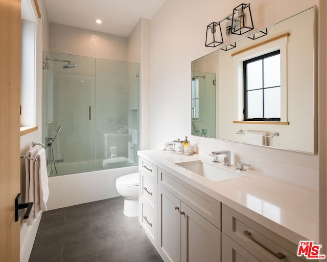 full bathroom with enclosed tub / shower combo, vanity, tile patterned floors, and toilet