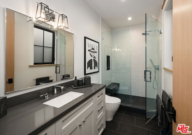 bathroom featuring tile patterned floors, toilet, a shower with shower door, and vanity