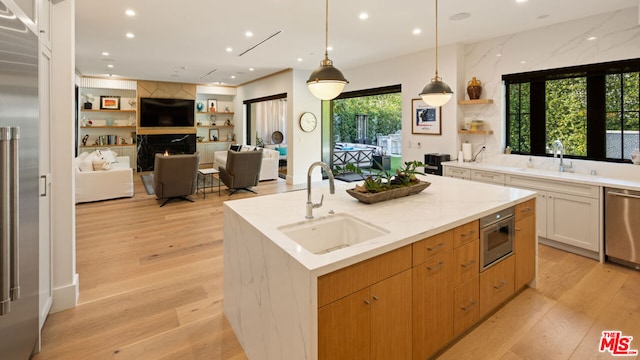 kitchen featuring white cabinetry, sink, dishwasher, and a large island with sink