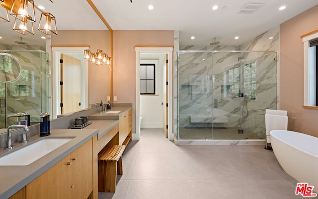 bathroom featuring vanity and independent shower and bath