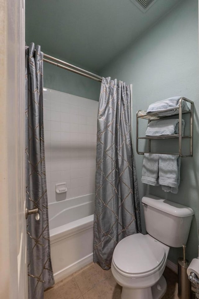 bathroom featuring shower / tub combo, tile patterned floors, and toilet