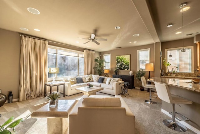 carpeted living room with ceiling fan