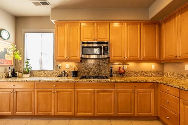 kitchen with appliances with stainless steel finishes and light stone counters