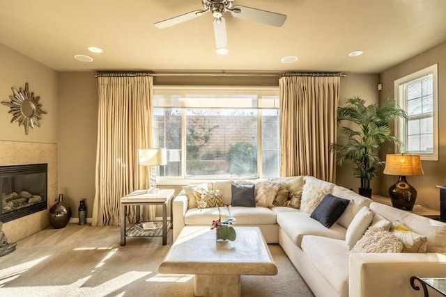 living room featuring ceiling fan, carpet flooring, and a tile fireplace