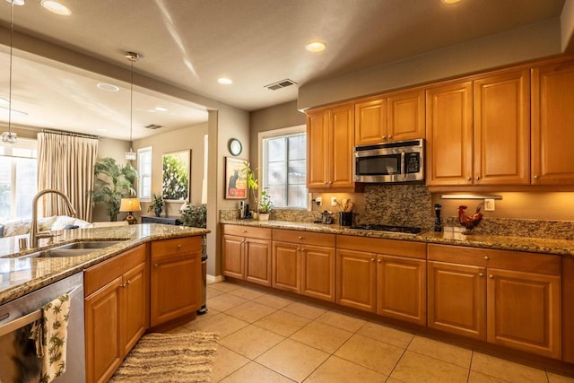 kitchen with sink, hanging light fixtures, stainless steel appliances, light stone counters, and light tile patterned flooring