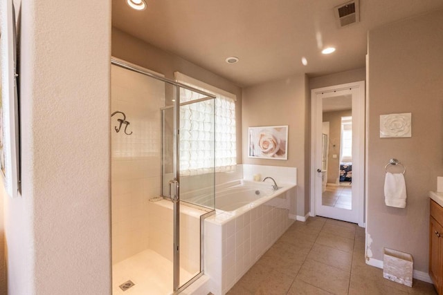 bathroom featuring vanity, tile patterned flooring, and plus walk in shower