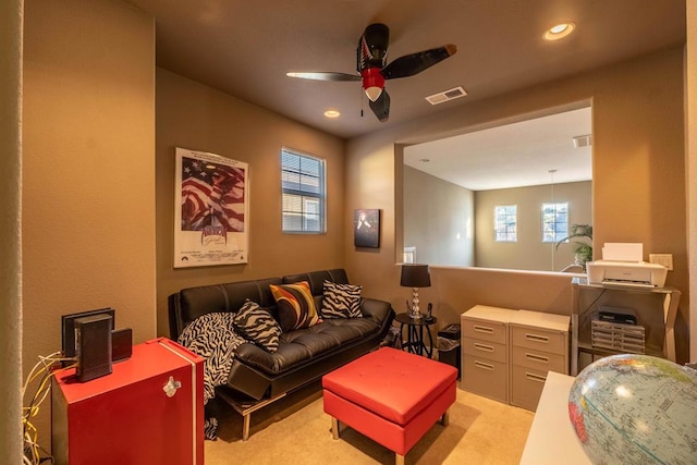 carpeted cinema room with ceiling fan