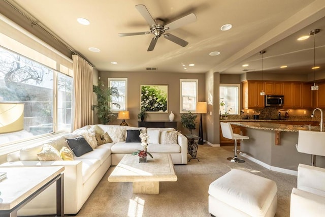 carpeted living room featuring ceiling fan