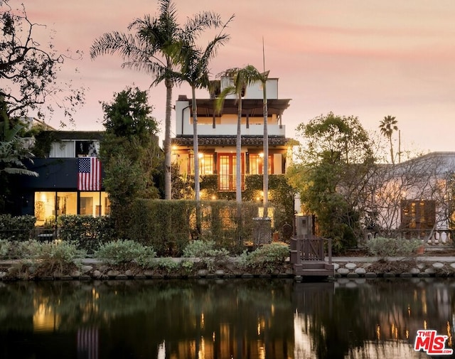 back house at dusk with a water view