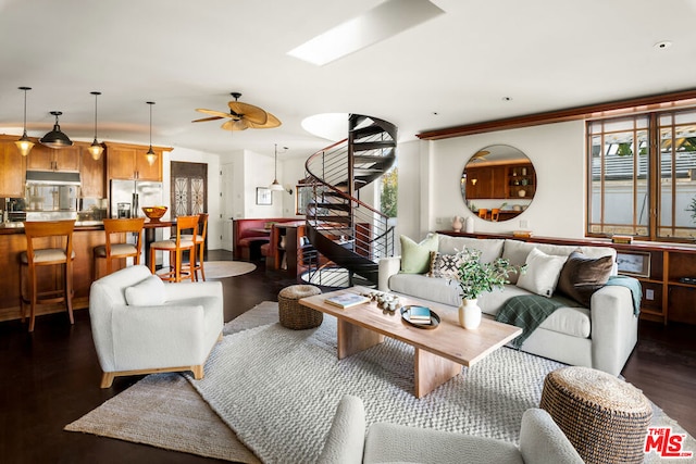 living room featuring ceiling fan, dark hardwood / wood-style flooring, and a skylight