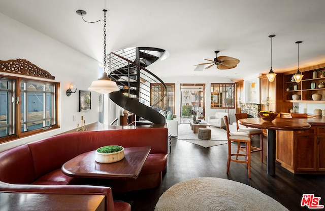 dining room with dark wood-type flooring, ceiling fan, and vaulted ceiling