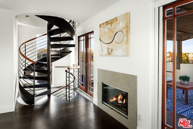 stairway with plenty of natural light, a premium fireplace, and wood-type flooring