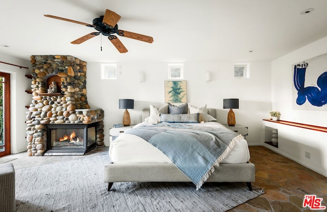 bedroom with a fireplace and ceiling fan